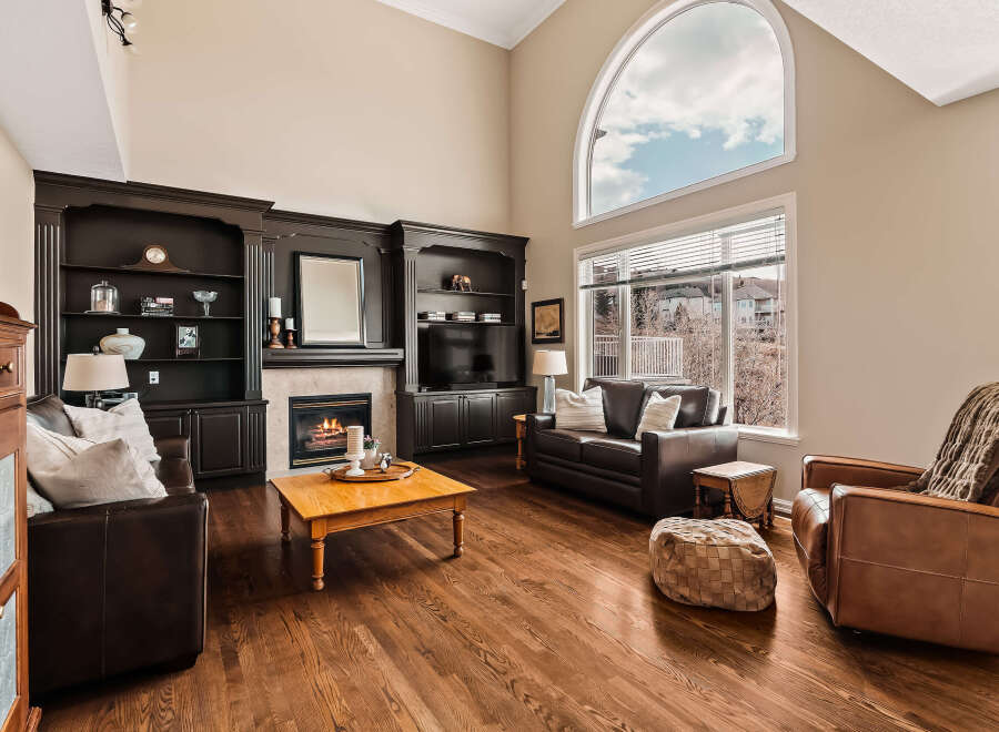 Step into luxury with this stunning living room, featuring a cozy fireplace and elegant built-in shelving.