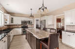 This stunning kitchen boasts a spacious island with a beautiful granite countertop, perfect for meal prep and casual dining.