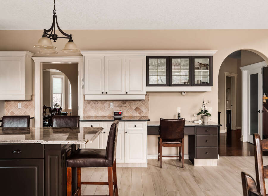 This stunning kitchen boasts elegant white cabinetry, a sleek black countertop, and a spacious island perfect for entertaining.