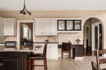 This stunning kitchen boasts elegant white cabinetry, a sleek black countertop, and a spacious island perfect for entertaining.