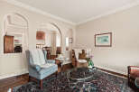 Step into this inviting living space, featuring elegant archways and a cozy ambiance.