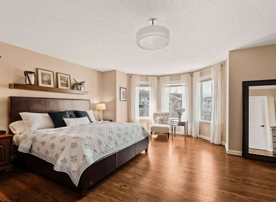 Step into this elegant bedroom, featuring a spacious layout and abundant natural light.