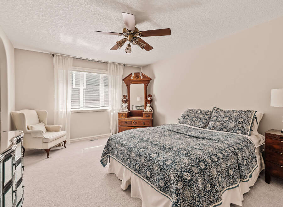 This inviting bedroom boasts a cozy atmosphere with its plush carpet and soft lighting.