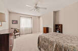 This spacious bedroom offers a serene retreat with its neutral color palette and ample natural light.