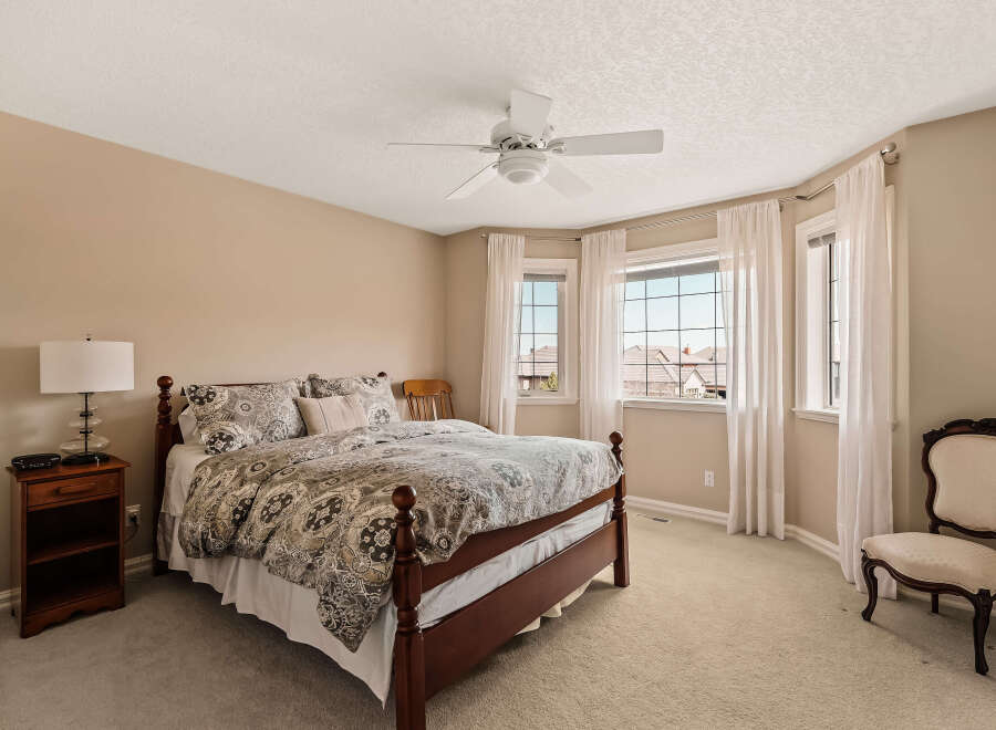 Step into this inviting bedroom, featuring a comfortable bed with stylish bedding and ample natural light.