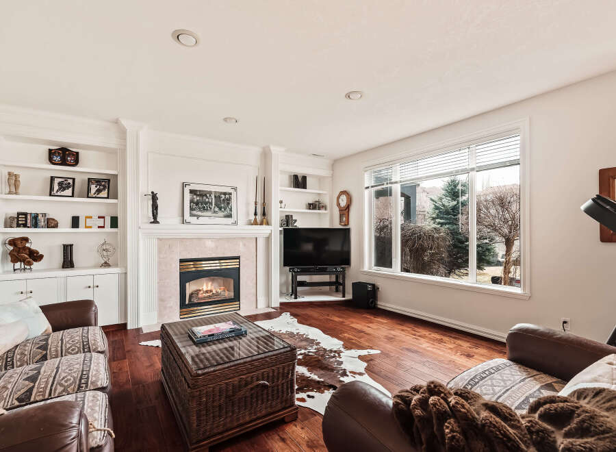 This stunning living room boasts a cozy fireplace, perfect for chilly evenings, and built-in shelving to showcase your favorite decor.