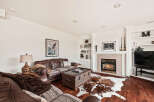 This stunning living room boasts a cozy fireplace, perfect for chilly evenings, and a beautiful cowhide rug adding a touch of rustic elegance.
