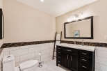 This stunning bathroom features a modern design with a dark wood vanity and a sleek white countertop.