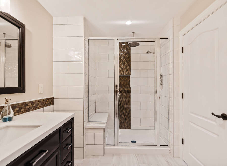 Step into luxury with this stunning bathroom featuring a modern glass shower and elegant white tile.