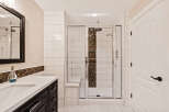 Step into luxury with this stunning bathroom featuring a modern glass shower and elegant white tile.