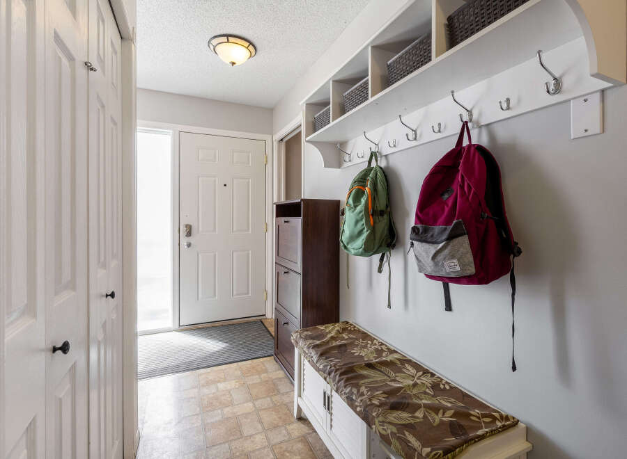 This inviting entryway features a practical design with a built-in shelf and coat hooks, perfect for organizing daily essentials.