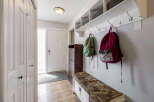 This inviting entryway features a practical design with a built-in shelf and coat hooks, perfect for organizing daily essentials.