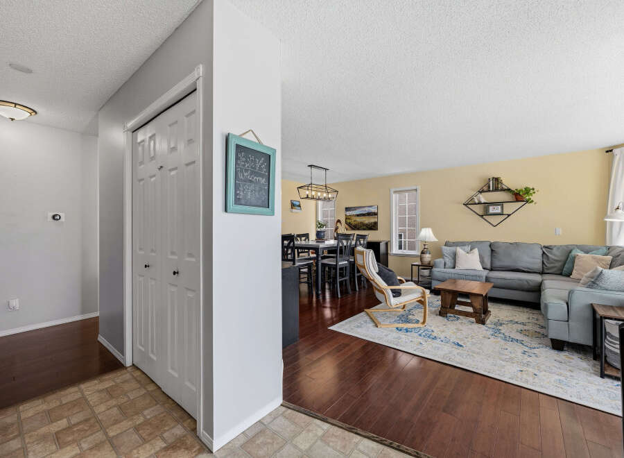 Step into this inviting home featuring a spacious living area with a cozy sectional sofa and a stylish rug.