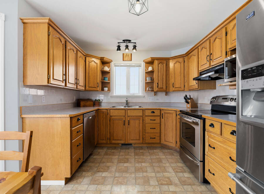 Step into this inviting kitchen, featuring warm wooden cabinetry that exudes timeless charm.