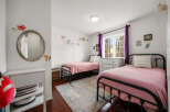 This charming bedroom features two twin beds with pink bedding, perfect for a shared space or guest room.