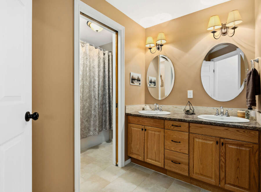 This beautiful bathroom features a double vanity with ample storage space, perfect for a busy household.