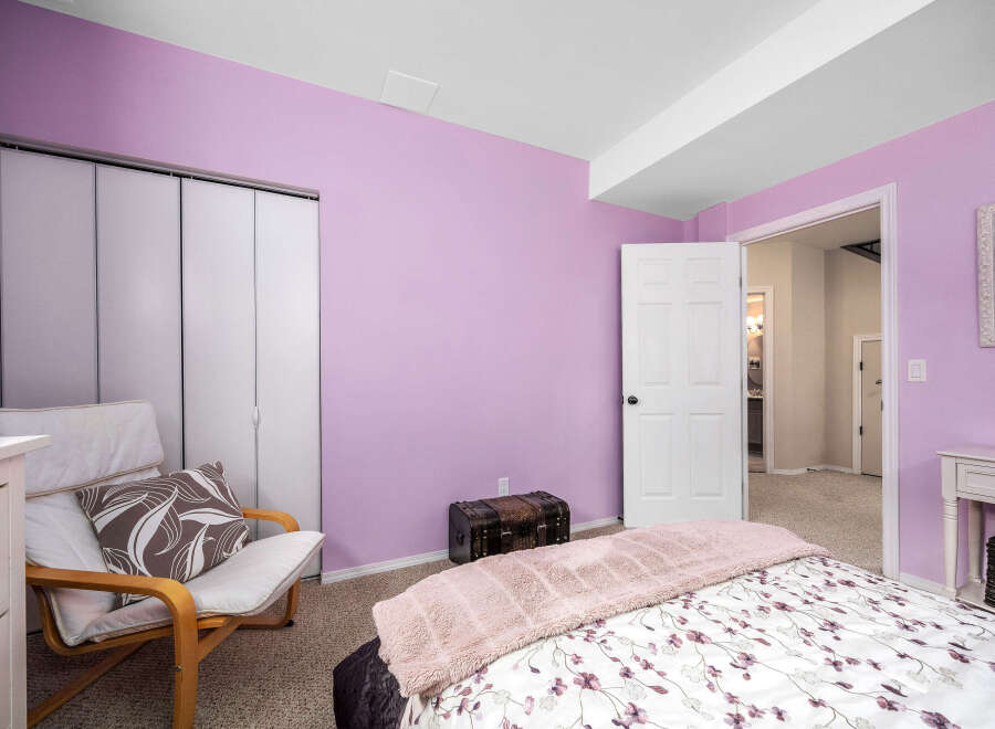 Step into this inviting bedroom, featuring a soothing lavender color scheme.
