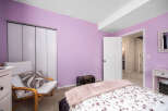 Step into this inviting bedroom, featuring a soothing lavender color scheme.