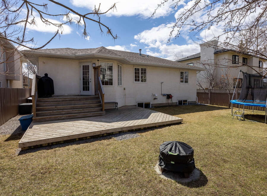 Enjoy outdoor living in this beautiful backyard! The property features a spacious wooden deck, perfect for entertaining or relaxing.