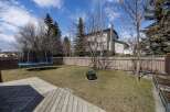 Enjoy outdoor living in this beautiful backyard! This property features a spacious deck, perfect for entertaining, and a lush lawn with a trampoline.