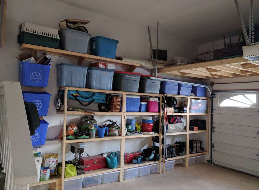 This garage offers ample storage solutions with custom-built shelving units and overhead storage.