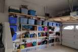 This garage offers ample storage solutions with custom-built shelving units and overhead storage.