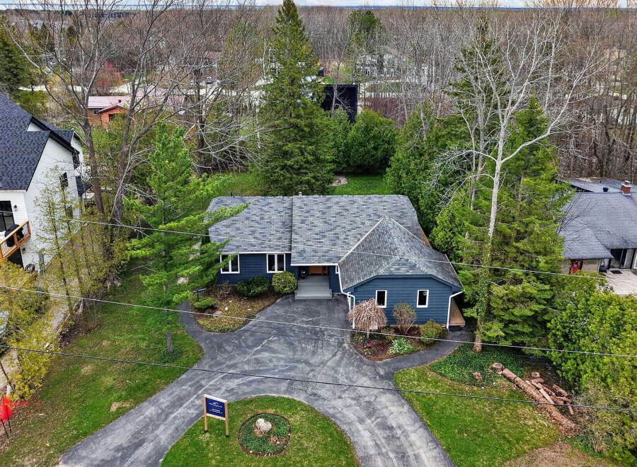 Discover this stunning property featuring a charming blue exterior and a beautifully landscaped yard.