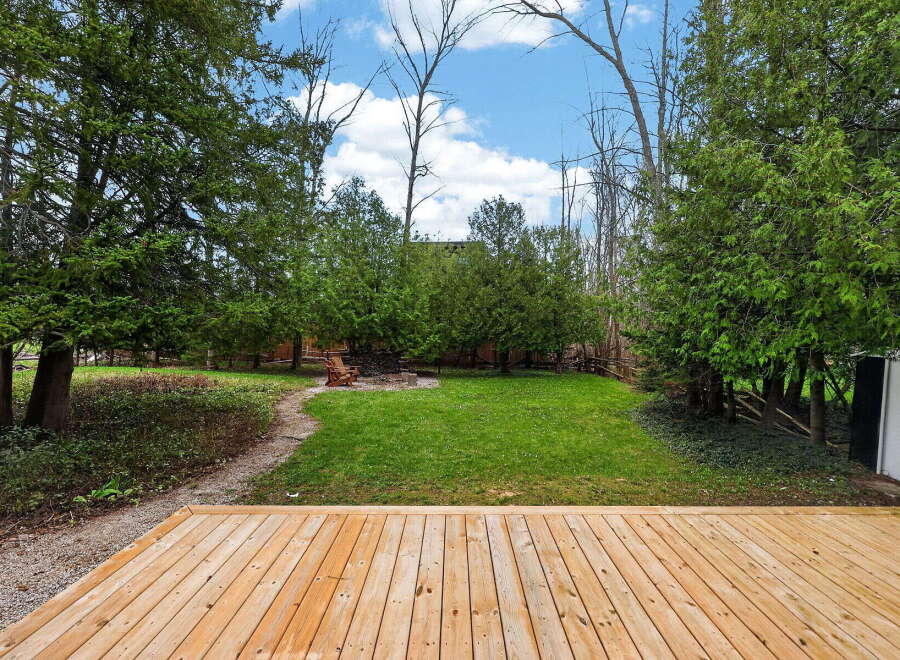Enjoy the tranquility of this stunning property, featuring a spacious wooden deck perfect for outdoor gatherings.
