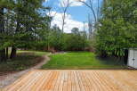 Enjoy the tranquility of this stunning property, featuring a spacious wooden deck perfect for outdoor gatherings.