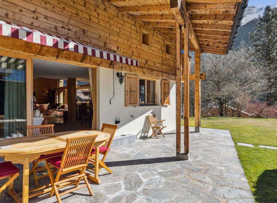 Experience the charm of this stunning property, featuring a beautiful wooden exterior and a welcoming outdoor patio.