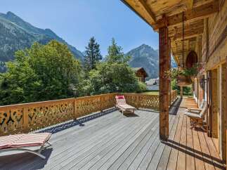 Experience breathtaking mountain views from this stunning wooden deck, perfect for relaxation and outdoor living.