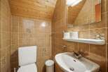 This charming bathroom features a unique design with wooden accents and warm-toned tiles.