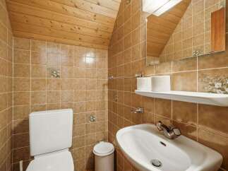 This charming bathroom features a unique design with wooden accents and warm-toned tiles.