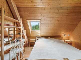 This cozy bedroom features a stunning wooden interior, creating a warm and inviting atmosphere.