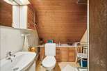 This charming bathroom features a unique sloped ceiling and warm wooden accents, creating a cozy and inviting atmosphere.