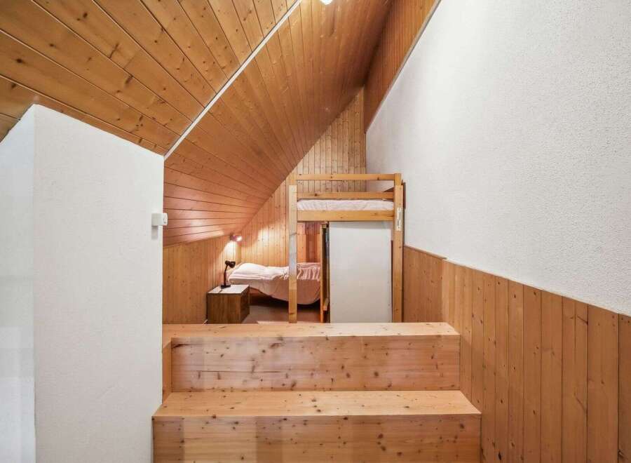 Discover the charm of this unique property featuring a cozy bedroom with a bunk bed and a warm wooden interior.