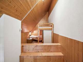 Discover the charm of this unique property featuring a cozy bedroom with a bunk bed and a warm wooden interior.