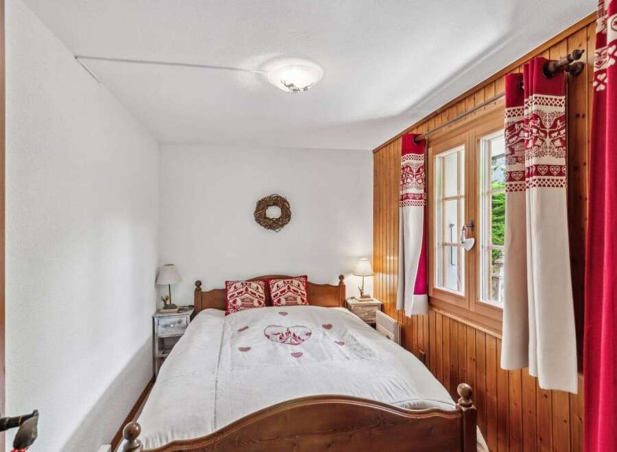 This charming bedroom features a cozy wooden bed frame and a beautifully designed quilt.