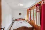 This charming bedroom features a cozy wooden bed frame and a beautifully designed quilt.