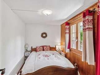 This charming bedroom features a cozy wooden bed frame and a beautifully designed quilt.
