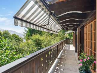 Enjoy breathtaking views from this stunning balcony! This property features a charming wooden balcony with a retractable awning, perfect for relaxing outdoors.