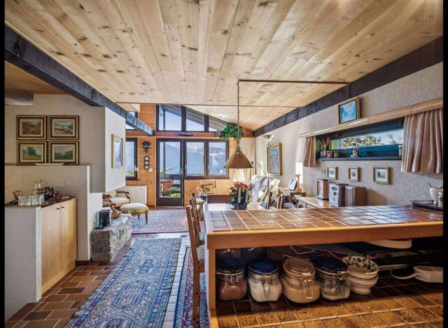 This stunning property boasts a warm and inviting interior with a unique wooden ceiling and exposed beams.