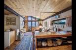 This stunning property boasts a warm and inviting interior with a unique wooden ceiling and exposed beams.