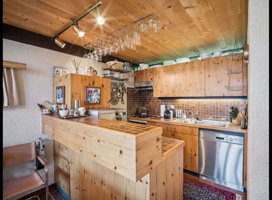 This charming kitchen boasts a warm, inviting atmosphere with its wooden cabinetry and ceiling.