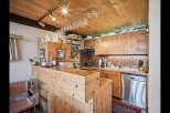 This charming kitchen boasts a warm, inviting atmosphere with its wooden cabinetry and ceiling.