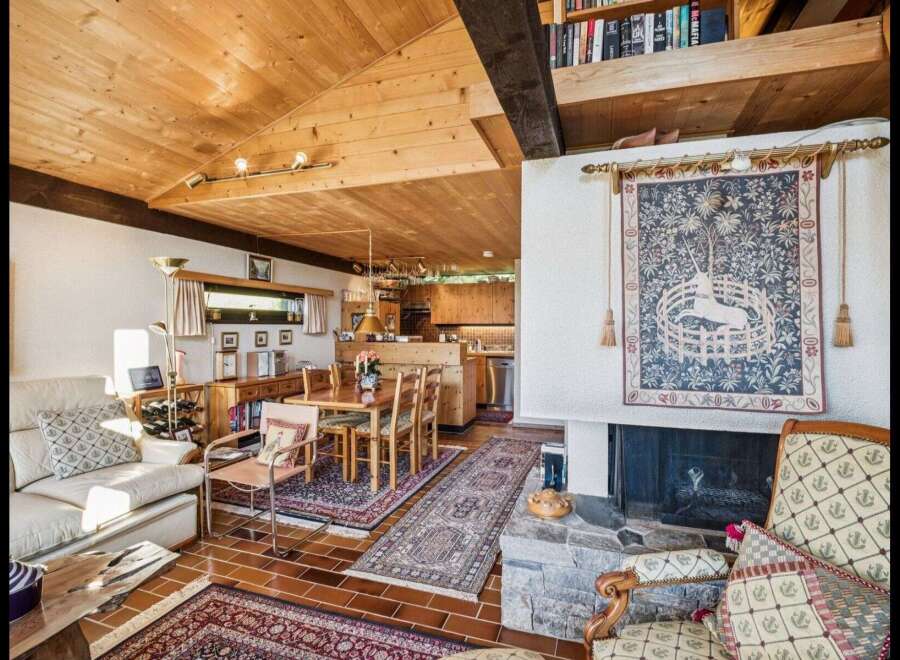 Step into this inviting home featuring a cozy living space with a fireplace and a warm wooden ceiling.