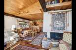 Step into this inviting home featuring a cozy living space with a fireplace and a warm wooden ceiling.