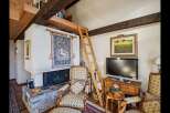 This charming property features a cozy living area with a unique loft space accessible by a wooden ladder.