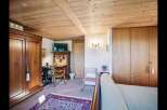 Step into this charming bedroom featuring a warm wooden ceiling and elegant wooden wardrobes.