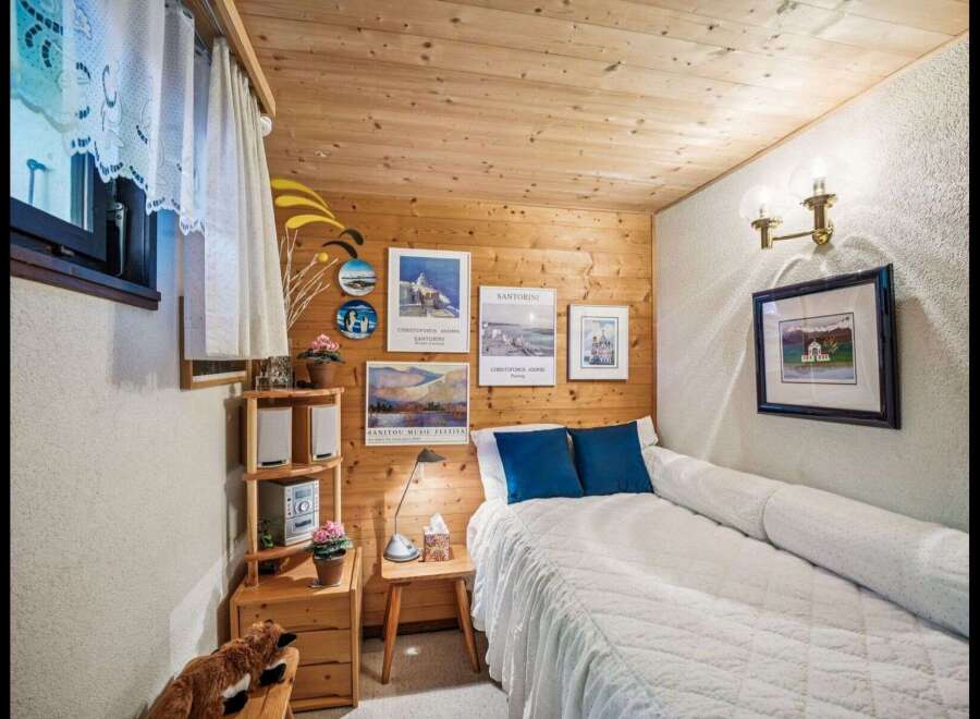Cozy bedroom with wooden paneling and a comfortable bed.